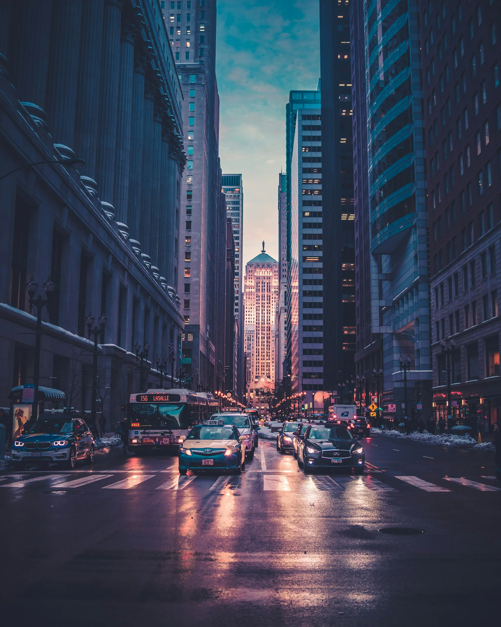 A person crossing a rain-darkened city street